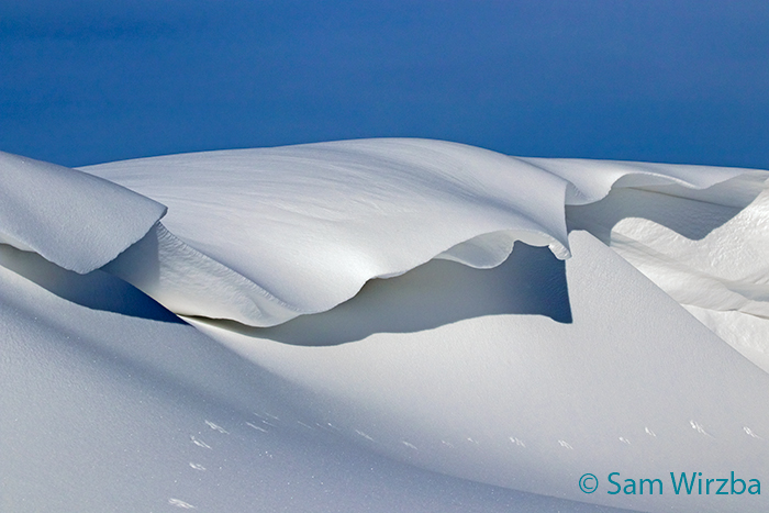 snow drifts take on the appearance of artistic snow scupltures